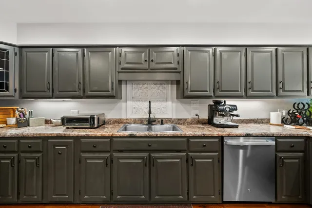 a kitchen with stainless steel appliances granite countertop a refrigerator a sink and a stove