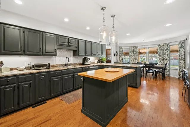 a view of a dining room and livingroom with furniture wooden floor a chandelier