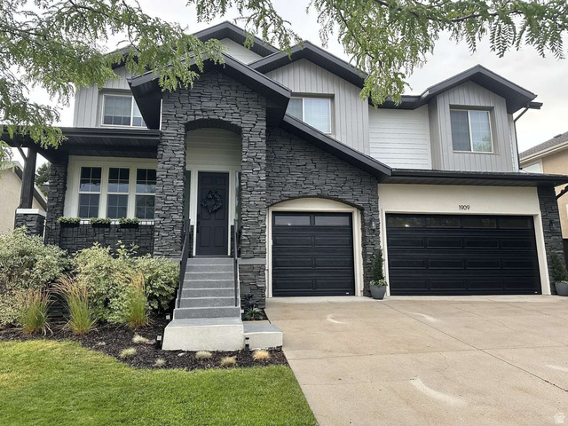 1909 Longbranch Drive Draper, UT 84020 - Photo 1 of 1 View of front of house with stone siding, concrete driveway, an attached garage, and covered porch