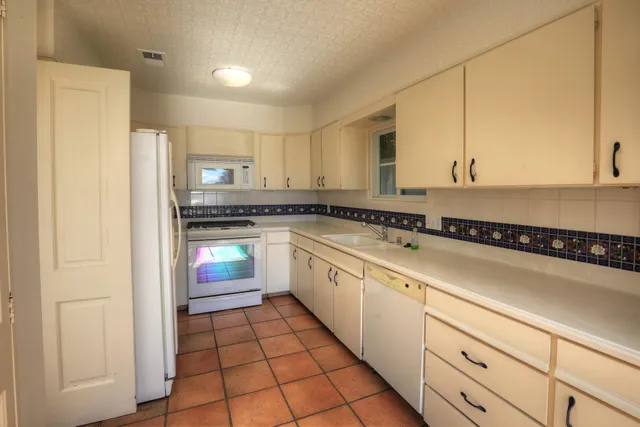 a kitchen with a cabinets and white appliances
