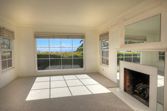 a view of empty room with windows and fireplace