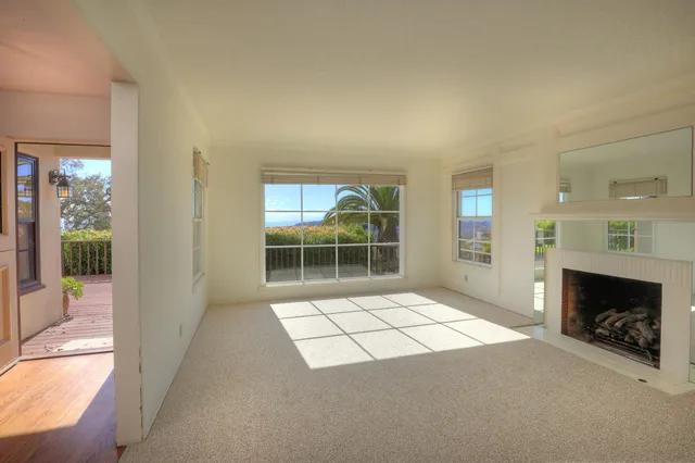 a view of a livingroom with a fireplace and window