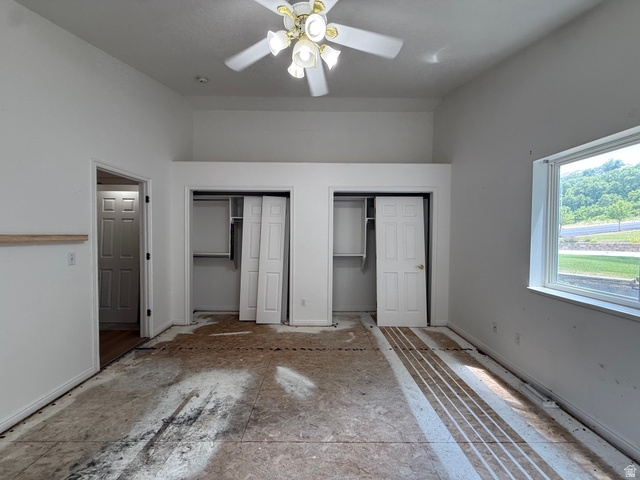 838 East Mountain Road Logan, UT 84321 - Photo 17 of 37 Spacious room featuring vaulted ceilings, a ceiling fan, dual closet spaces with bi-fold doors, and a large window providing ample natural light