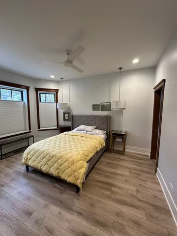 a bed sitting in a spacious bedroom next to a window