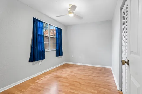 a view of an empty room with window and wooden floor