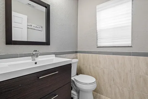 a bathroom with a sink mirror and toilet