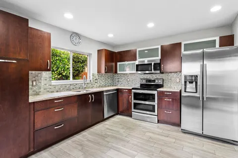 a kitchen with stainless steel appliances granite countertop a refrigerator and a sink