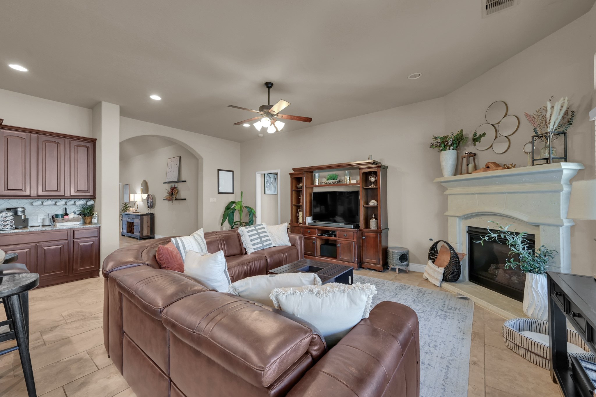 3814 Trophy Ridge Spring, TX 77386 - Photo 15 of 39 This inviting living room features a spacious layout with a stone fireplace. The room is accented by a ceiling fan offering a warm and functional space for relaxation and entertainment.
