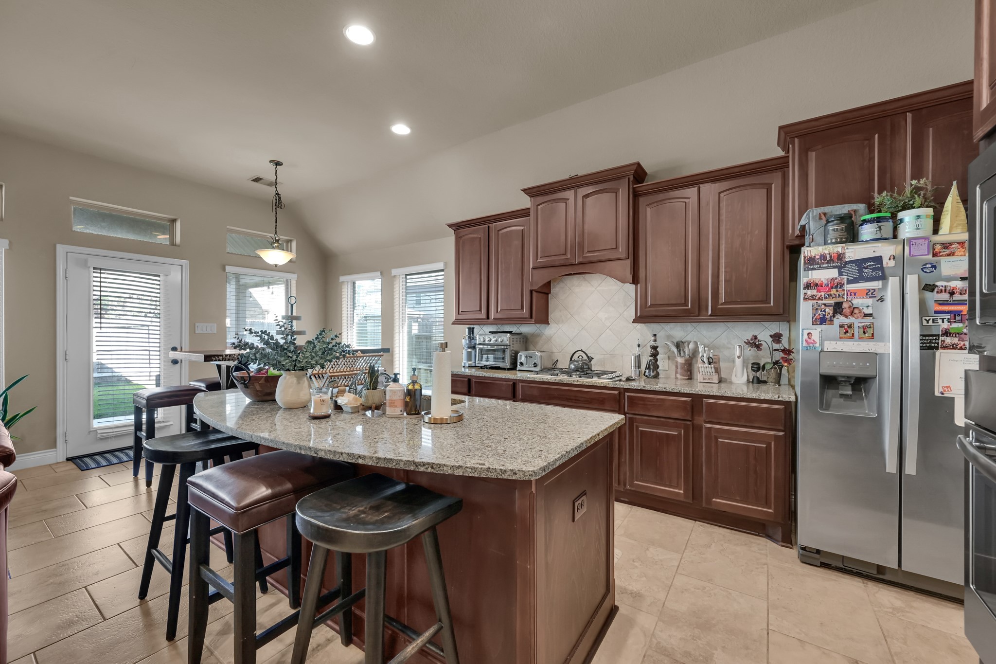 3814 Trophy Ridge Spring, TX 77386 - Photo 17 of 39 a kitchen with stainless steel appliances granite countertop a table chairs sink refrigerator and cabinets