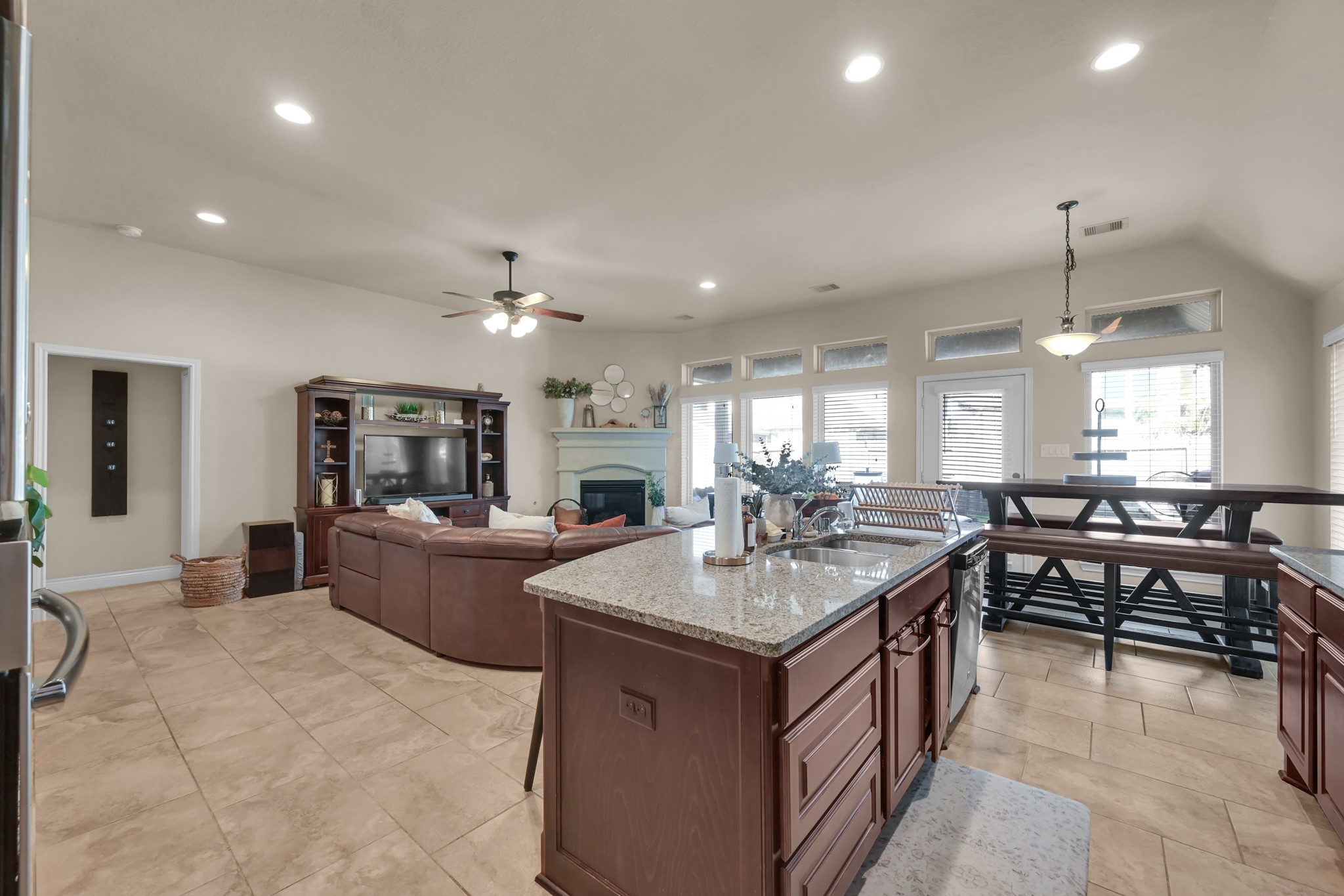 3814 Trophy Ridge Spring, TX 77386 - Photo 18 of 39 This spacious open-concept living area features a modern kitchen with a large granite island, ample n room for seating, and abundant natural light from multiple windows. The cozy living space is perfect for family gatherings.