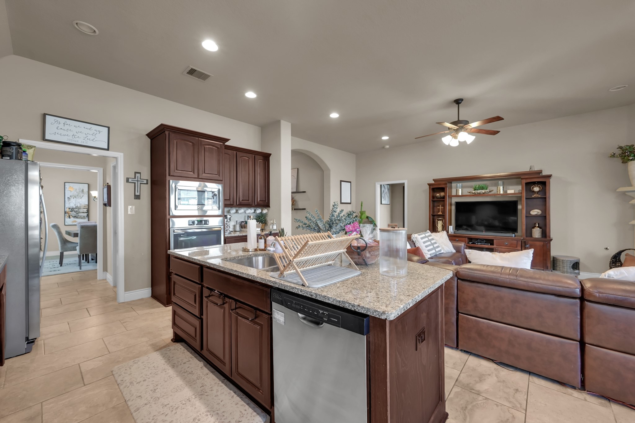 3814 Trophy Ridge Spring, TX 77386 - Photo 19 of 39 This inviting open-concept space features a modern kitchen with granite countertops, dark wood cabinetry, and stainless steel appliances. It seamlessly flows into a cozy living area perfect for family gatherings.