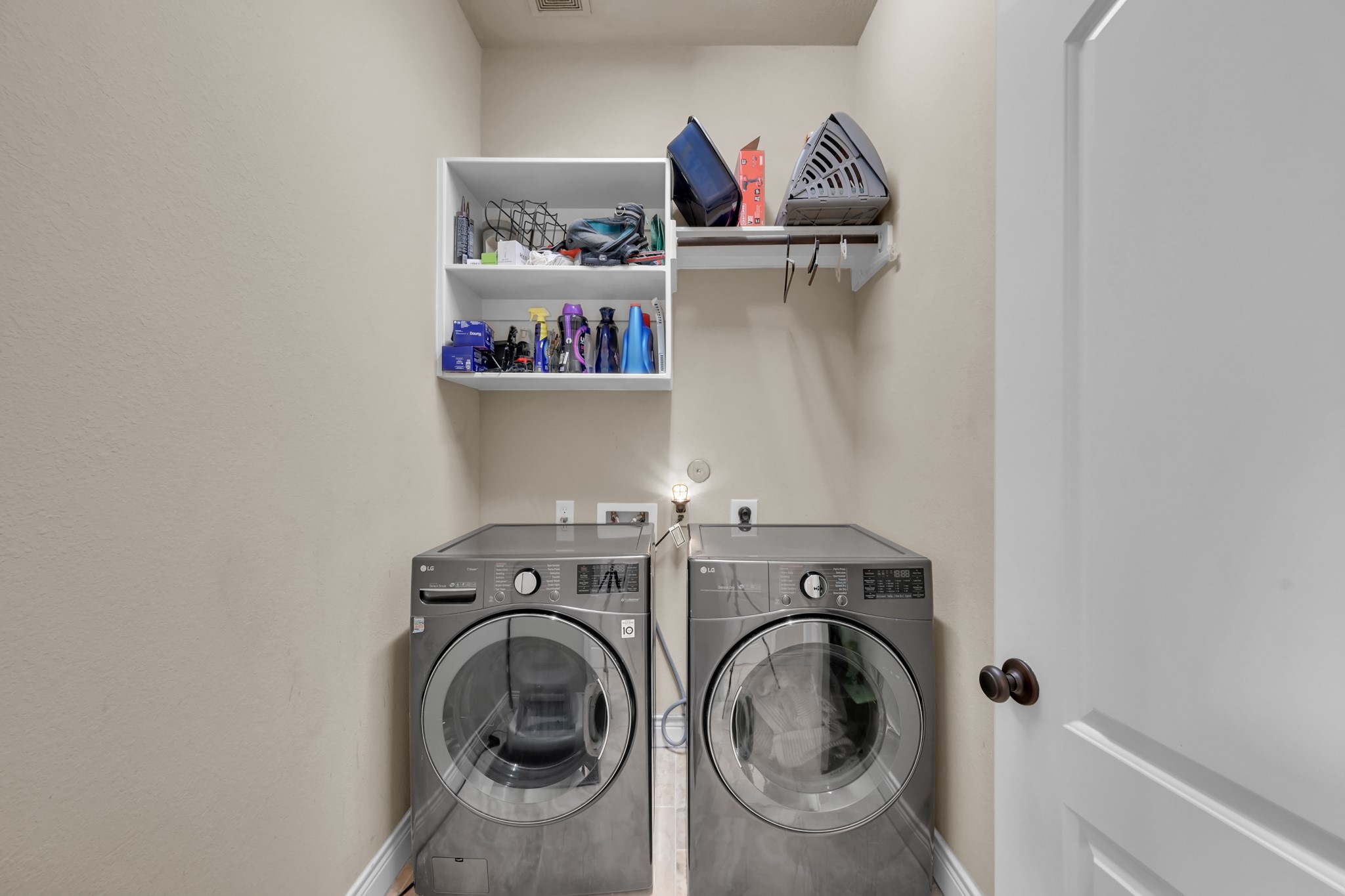 3814 Trophy Ridge Spring, TX 77386 - Photo 28 of 39 This photo shows a compact laundry room. There are two shelves for storage. The space is efficiently organized to maximize utility.