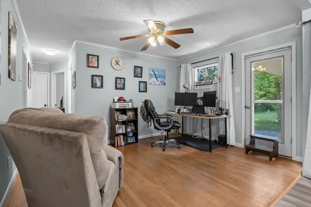 a view of a livingroom with workspace and a window