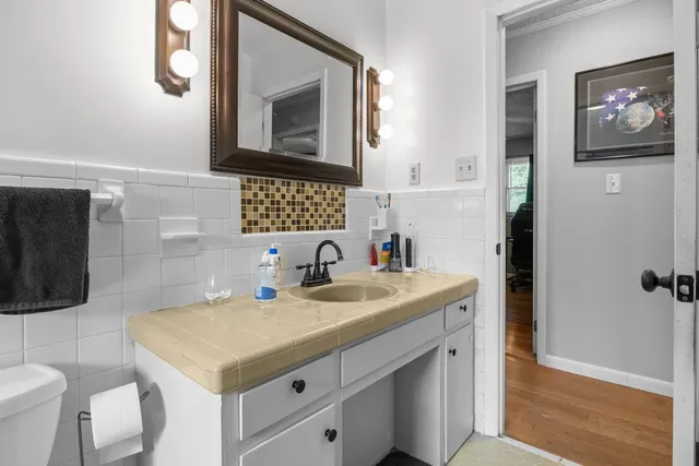 a bathroom with a sink a toilet and mirror