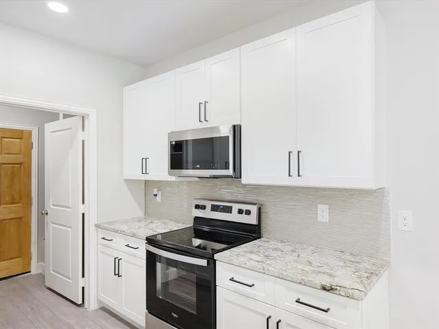 a kitchen with white cabinets stainless steel appliances and sink