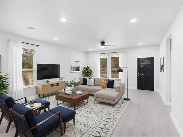 a living room with furniture flat screen tv and a large window