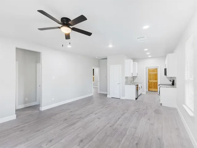 a view of a livingroom with a ceiling fan wooden floor and a ceiling fan