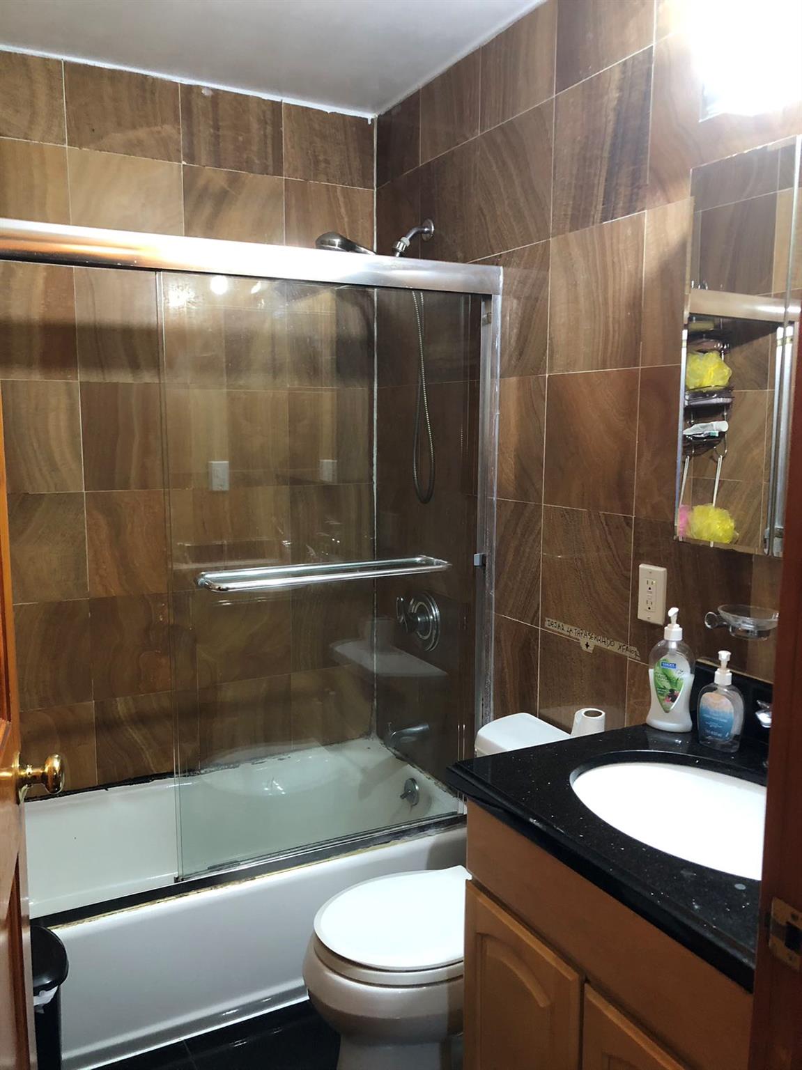 37-33 107th Street, Unit 4A Queens, NY 11368 - Photo 6 of 7 a bathroom with a granite countertop sink toilet and shower