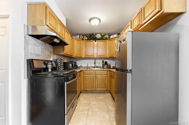 a kitchen with stainless steel appliances granite countertop a refrigerator a sink and a stove