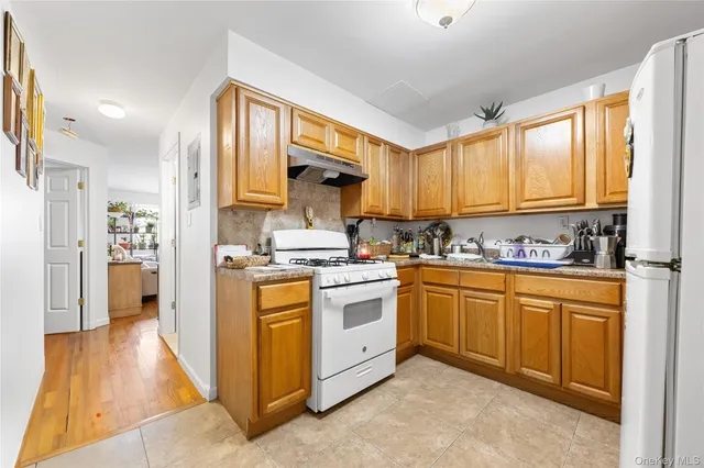 a kitchen with stainless steel appliances granite countertop a stove a sink and a refrigerator