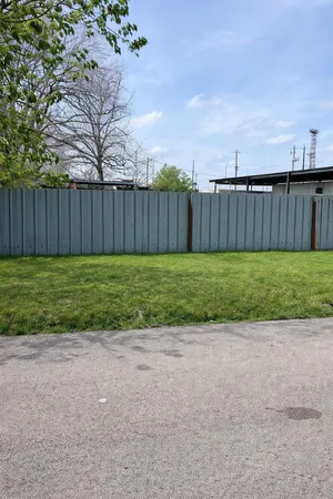 a view of a yard with wooden fence