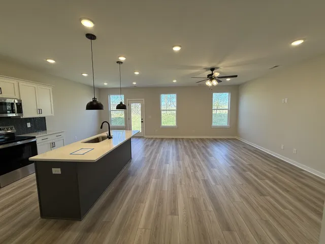 a large kitchen with stainless steel appliances granite countertop a large counter top a sink and a dishwasher