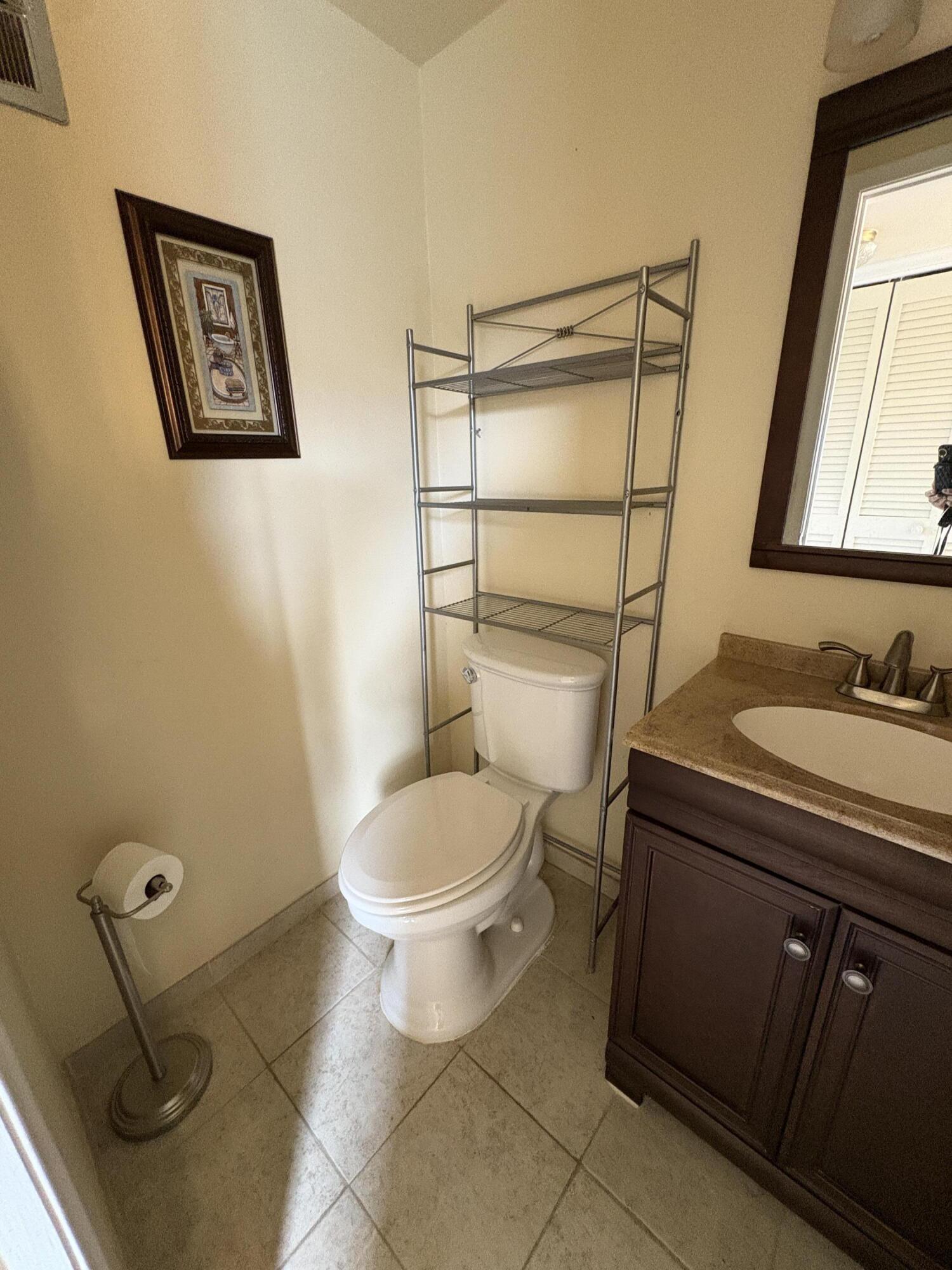 113 Waltham East West Palm Beach, FL 33417 - Photo 5 of 24 a bathroom with a granite countertop toilet sink and mirror