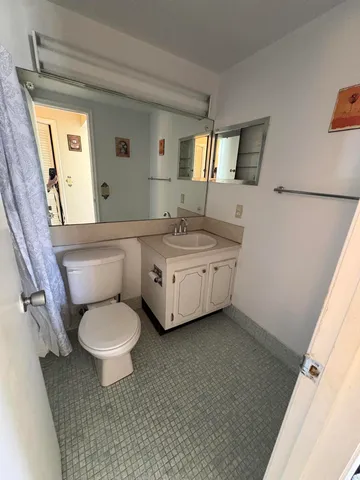 a bathroom with a sink toilet a mirror and window
