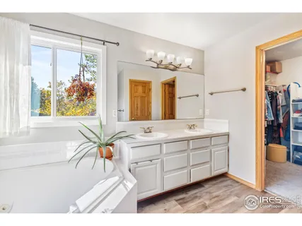 a bathroom with a tub a sink and a large mirror