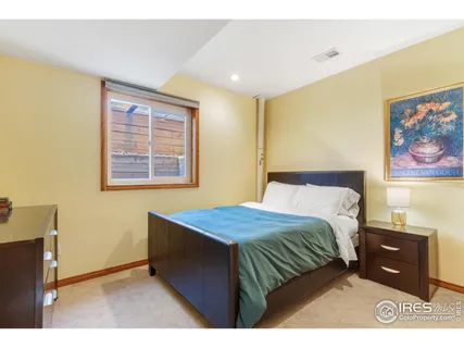 a bedroom with a bed and a wall painting