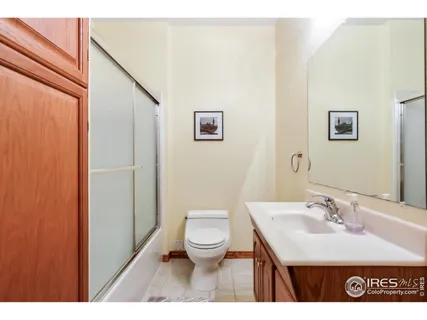 a bathroom with a granite countertop sink toilet and a mirror