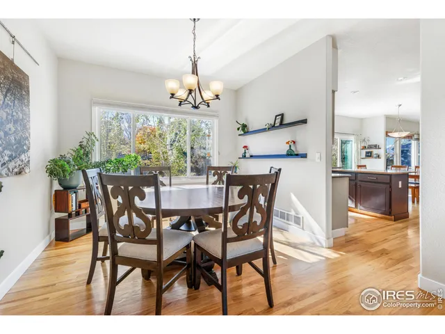 a view of a dining room and livingroom furniture wooden floor a chandelier