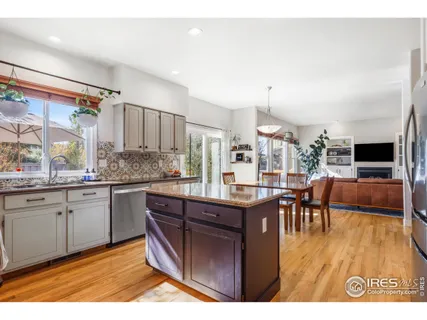 a kitchen with stainless steel appliances granite countertop a table chairs and a refrigerator