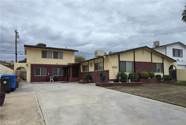 a view of a house with a barbeque and wooden stairs