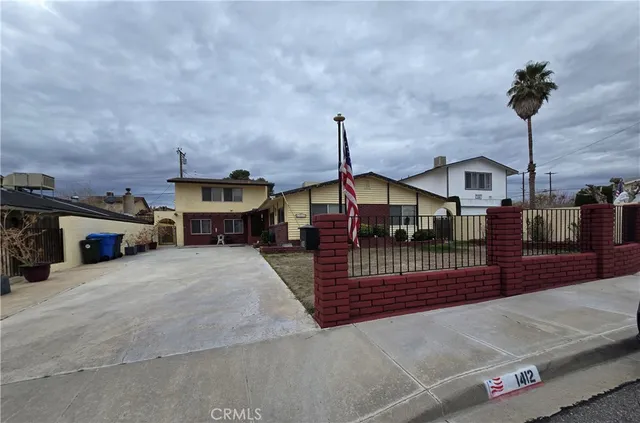 a front view of a house with a garden and car parked