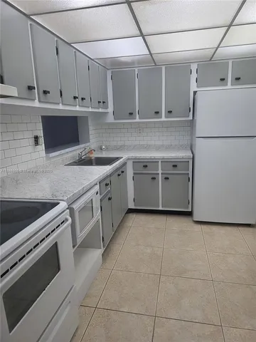 a kitchen with a stove sink and cabinets