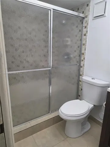 a white toilet next to a bathroom sink