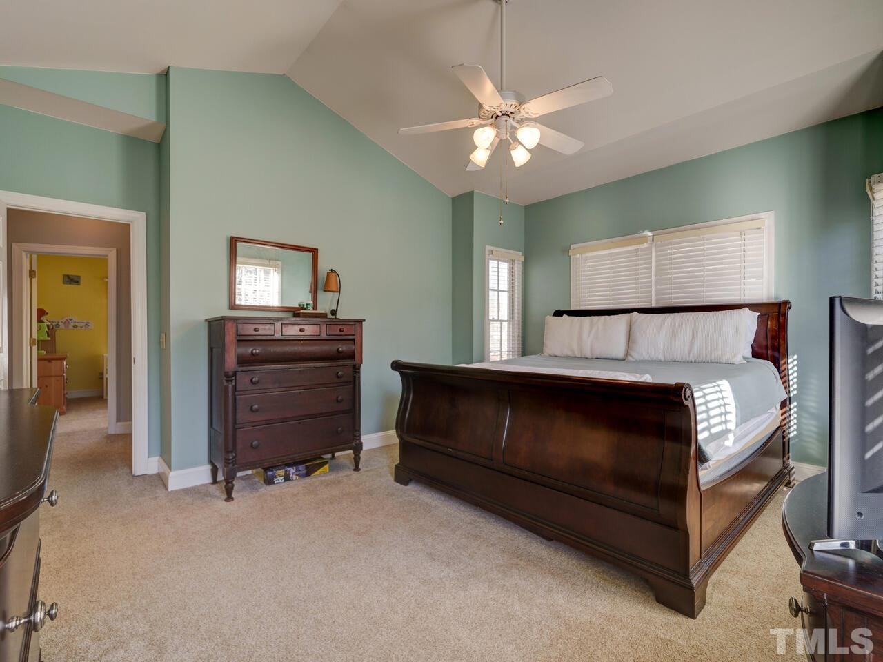 11816 Radner Way Raleigh, NC 27613 - Photo 23 of 54 a bedroom with a bed and a chandelier