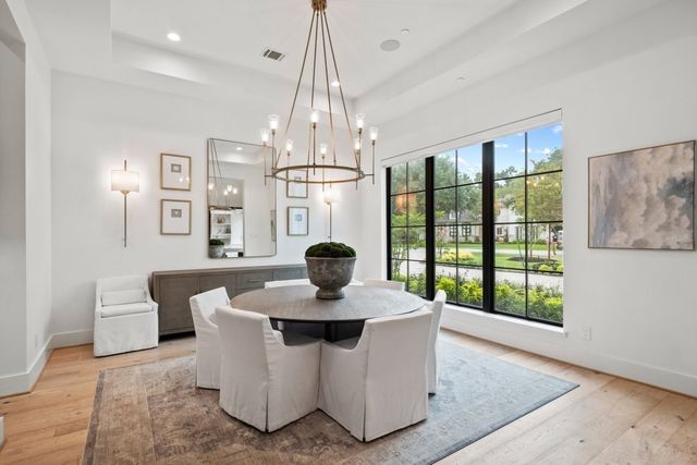 a dining room with furniture a chandelier and wooden floor