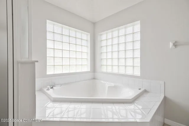 a bath tub sitting in a bathroom next to a window
