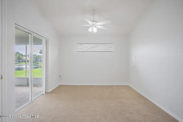 an empty room with a ceiling fan and window