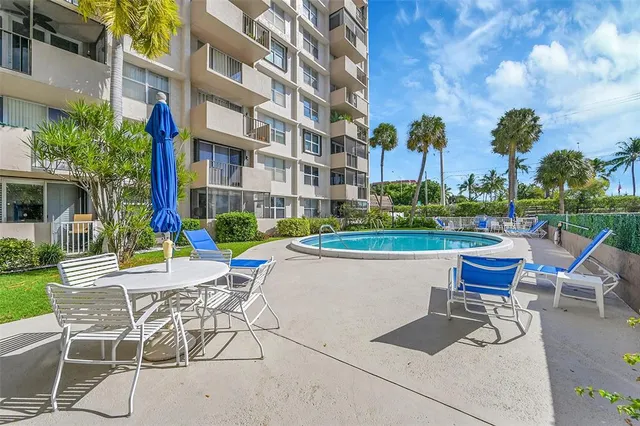 a view of swimming pool with outdoor seating and a garden
