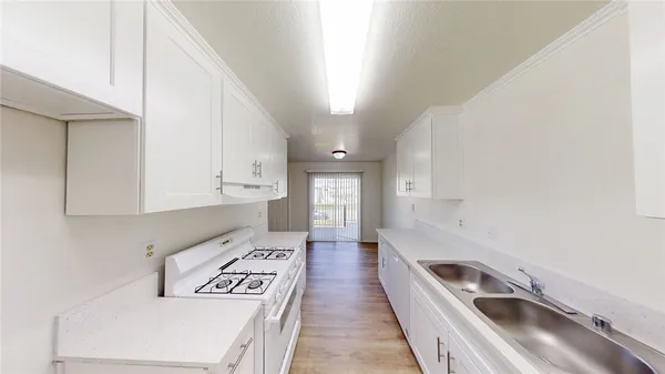 a kitchen with a sink a stove and cabinets