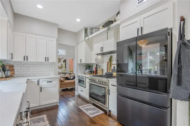 a kitchen with stainless steel appliances granite countertop a stove and white cabinets