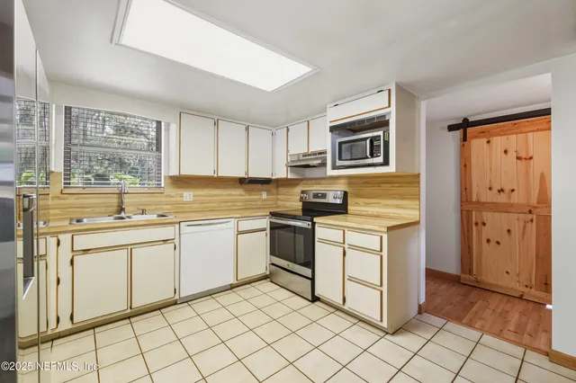a kitchen with a stove sink and cabinets