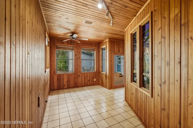 a view of a hallway with wooden floor and windows