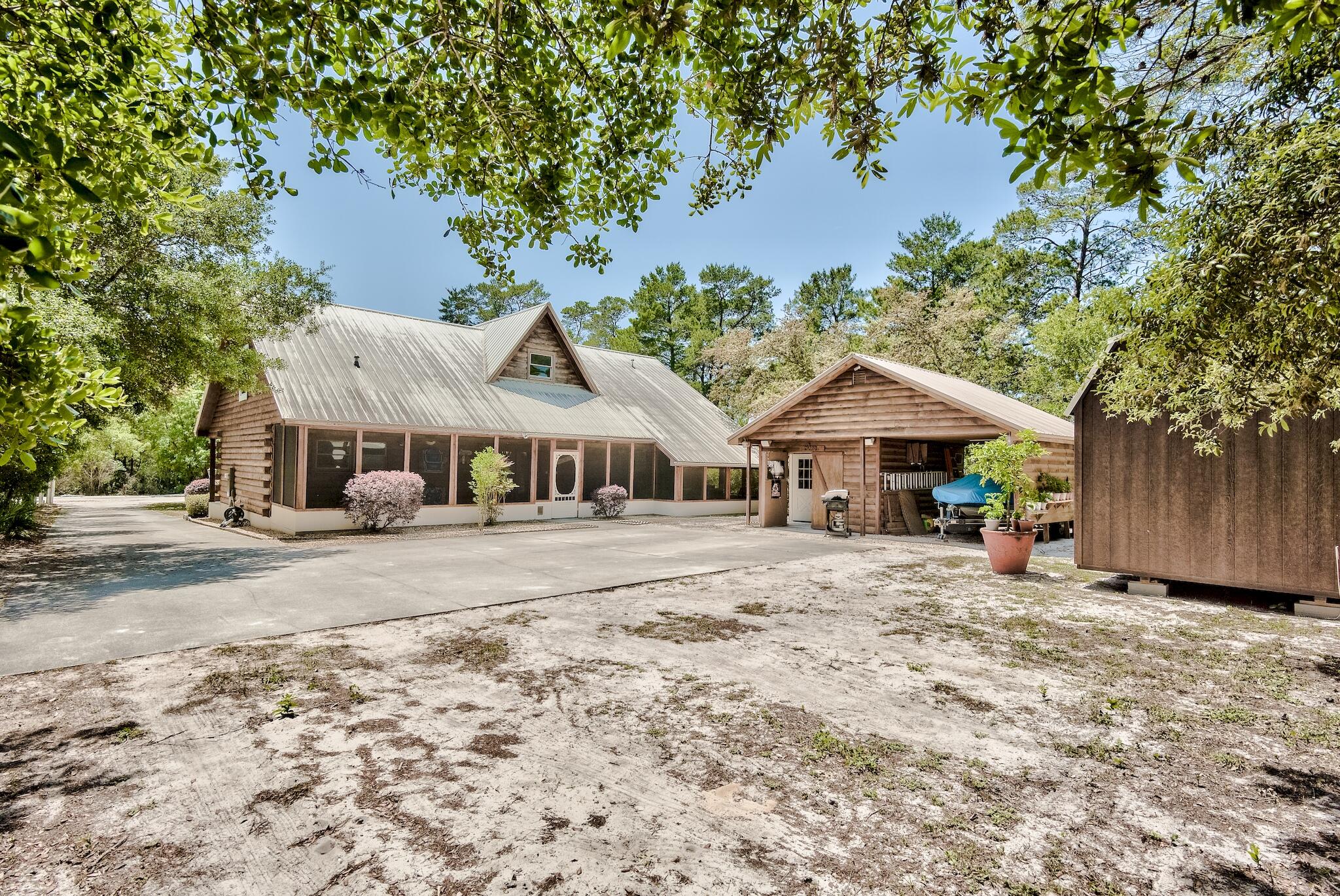 279 Pinewood Lane Inlet Beach, FL 32461 - Photo 39 of 48 a front view of a house with a dirt yard and a large tree