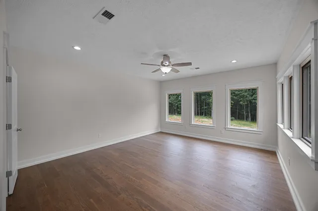 an empty room with wooden floor and window