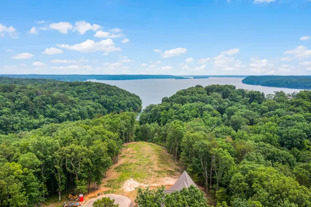an aerial view of ocean and residential houses with outdoor space