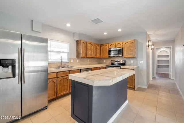 a kitchen with a refrigerator a sink and a stove top oven with wooden floor